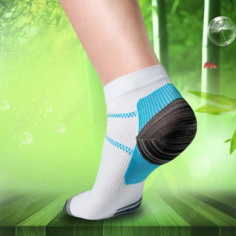White compression socks with blue accents and a black heel, worn on a person's leg.