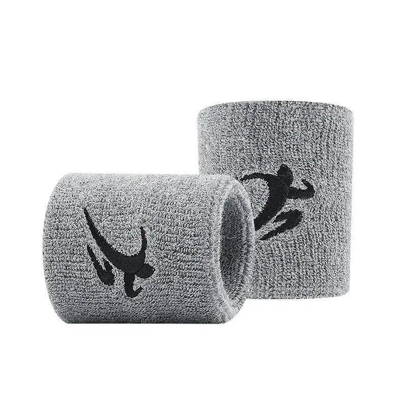 Graue Strick-Sport-Armbänder aufgerollt, die ein dunkles Silhouetten-Design zeigen.