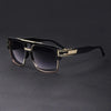 A pair of classic retro square sunglasses with black frames and gold accents resting on a dark surface.