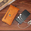 Bolso de cuero naranja tipo flip, sosteniendo un smartphone negro y auriculares blancos sobre una superficie de madera.