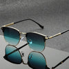 Vintage square metal frame sunglasses with gold accents and teal lenses resting on a reflective surface.