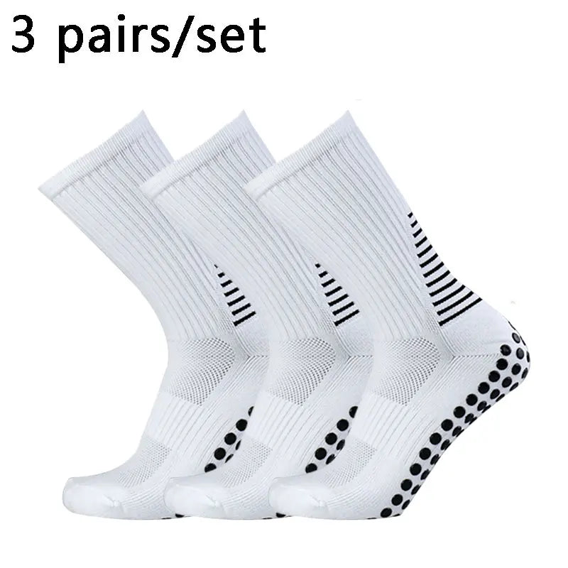 Three pairs of white performance football socks laid out for sale