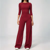 A woman wearing a long-sleeved maroon yoga and fitness leggings set.