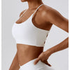 Modelo vistiendo un sujetador deportivo en forma de U blanco para fitness y yoga.