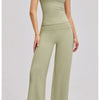 A woman models a sage green women's premium fitness tracksuit top and matching trousers.