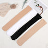 A set of opaque thigh high elastic socks in beige, white, and black laid out on a light surface.