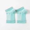 A pair of light blue therapeutic compression socks for foot and ankle pain relief.
