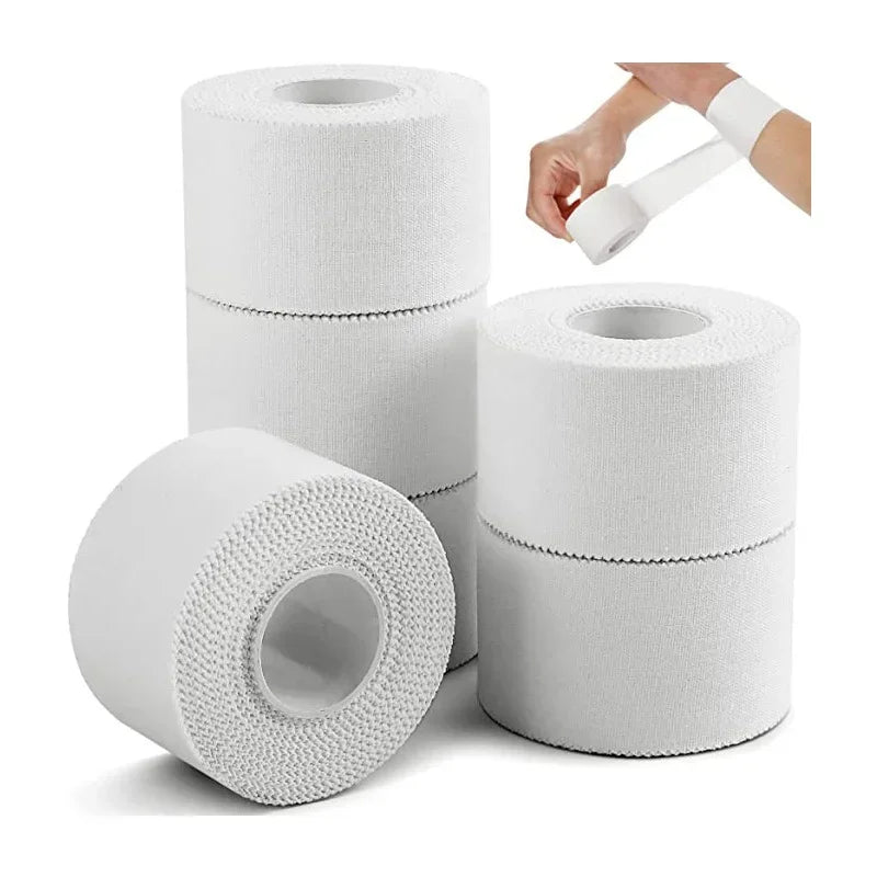 Rolls of white athletic training tape with a dispenser and hand applying the tape.