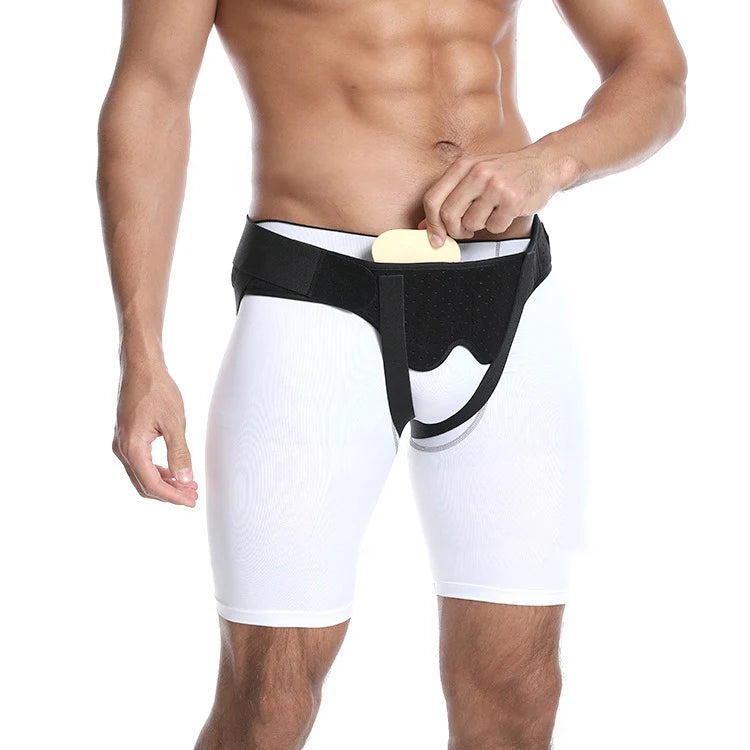 A muscular person wearing a black hernia support belt over white athletic shorts.