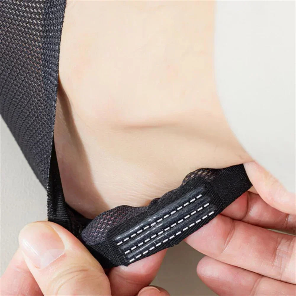 Une main tient une chaussette en filet antidérapante noire pour hommes.