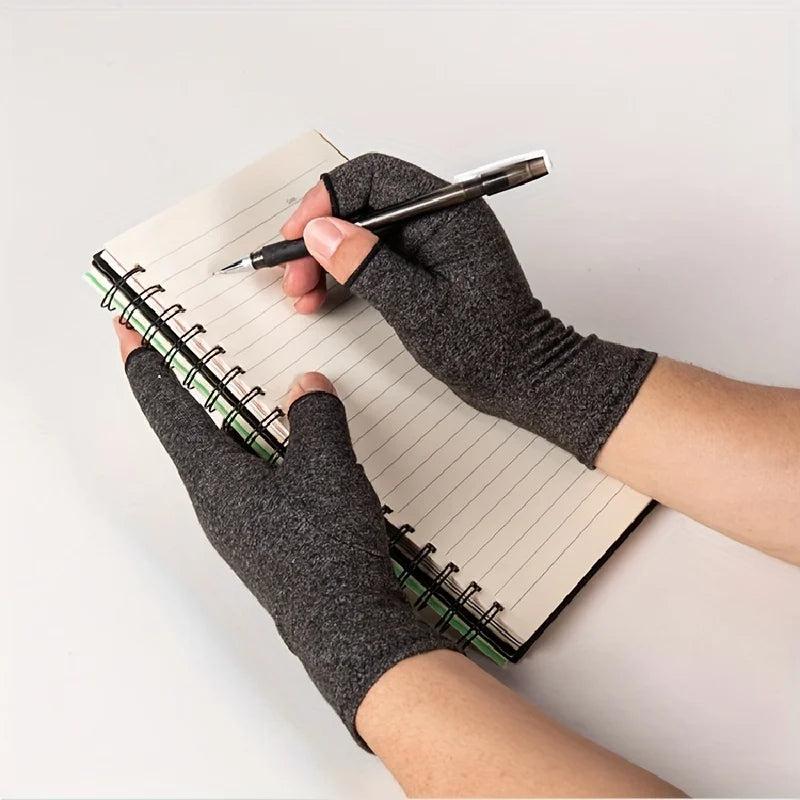 A hand wearing fingerless breathable gloves is writing in a spiral notebook with a pen.
