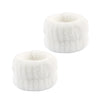 A set of white microfiber spa headband and wristband, cylindrical in shape.