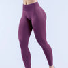 Modelo usando leggings de yoga sin costuras de cintura alta color púrpura intenso.