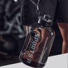 Klare wiederverwendbare Sportflasche mit schwarzem Deckel vor dunklem Hintergrund.