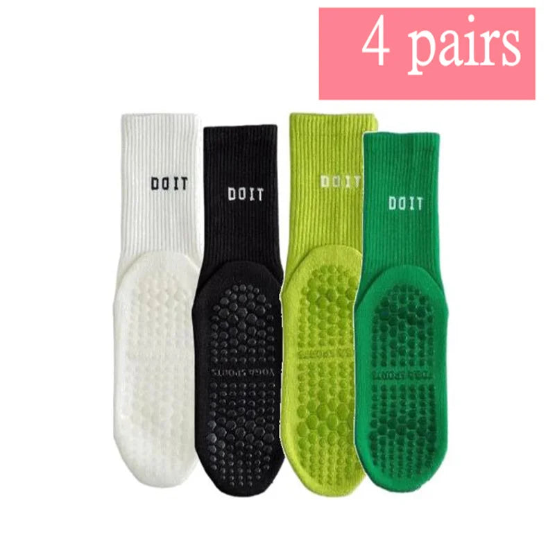 Vier Paar atmungsaktiver rutschfester Yoga- und Fitnesssocken in Weiß, Schwarz, Limettengrün und Smaragdgrün.