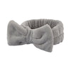A gray microfiber spa headband and wristband set with a soft, fuzzy texture.