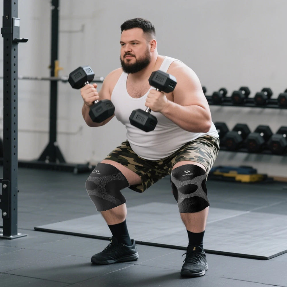 Muskulöser Mann macht Kniebeugen mit Kompressionshosen und hebt Hanteln im Fitnessstudio.