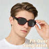 A man is modeling a pair of black and red wrap-around sunglasses designed for glasses compatibility.