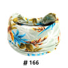 Un bandeau en coton stretch et bohème vert clair avec un motif de feuille florale aux tons bleu, orange et marron.