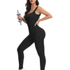 A woman wearing a black ribbed nylon bodycon jumpsuit posing with a lightsaber.