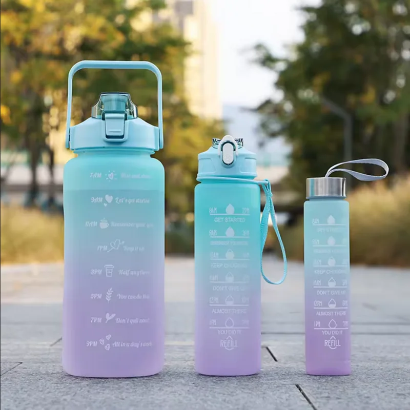 A light blue sports water bottle with a straw and a teal colored cap is shown on a gray surface.