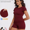 A model wearing a maroon sports casual tracksuit consisting of a short-sleeved top and matching shorts.