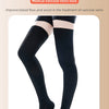 A pair of black medical compression socks being worn on a person's legs.