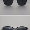 Black metal frame sunglasses with dark lenses shown against a gray background.