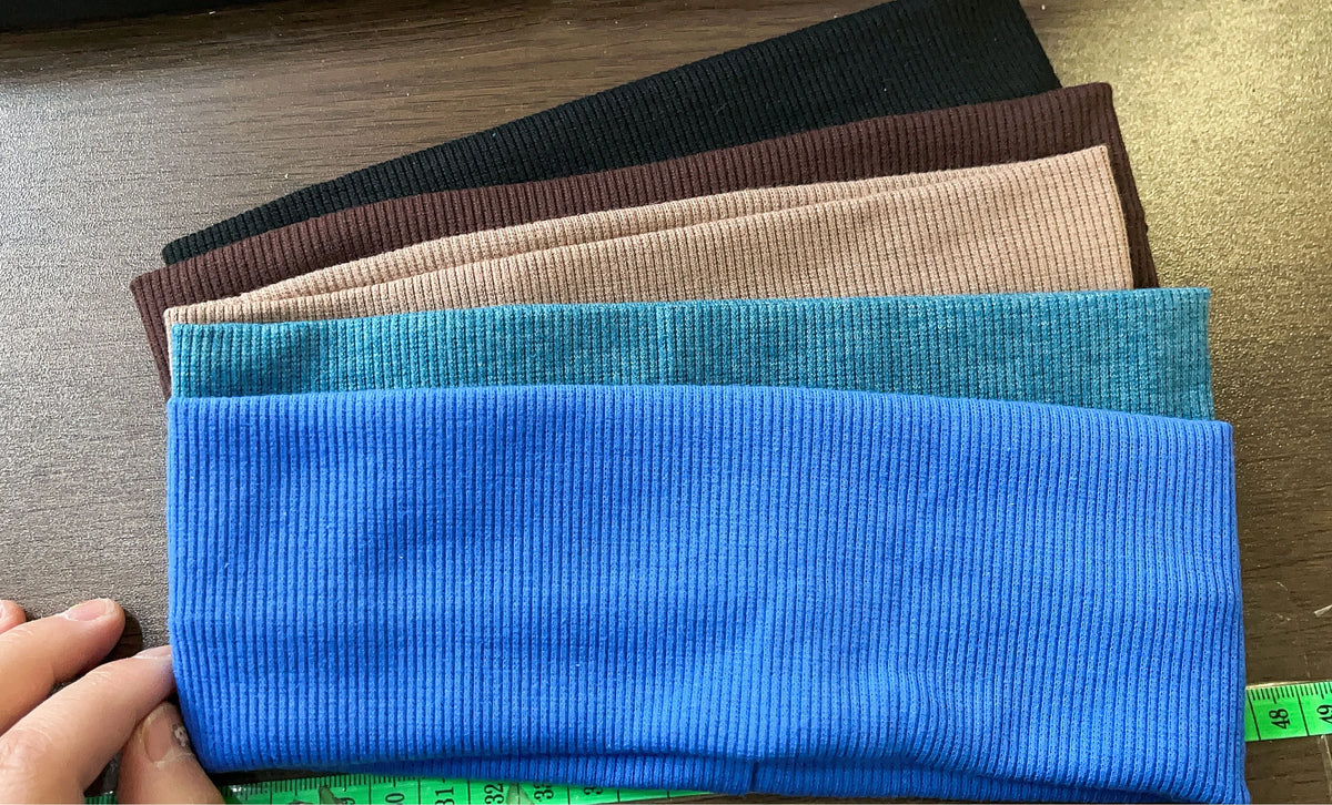 A stack of five blue elastic hairbands for fitness and yoga, showing various shades of blue.