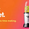 Una licuadora Magic Bullet plateada junto a ingredientes frescos como lima, aguacate y chiles.