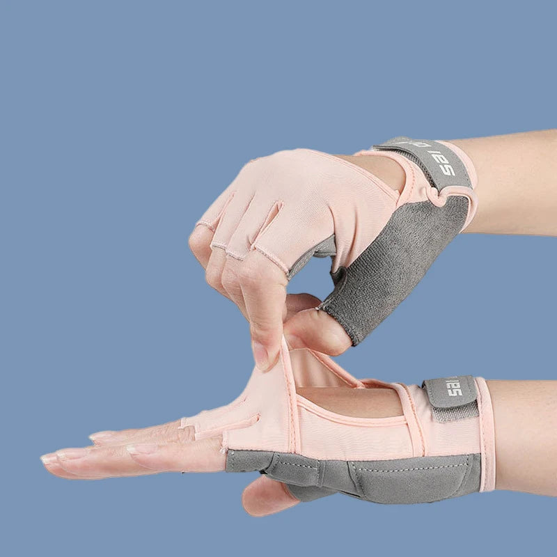 A hand wearing pink half finger sports gloves with gray accents, shown in a close-up view.