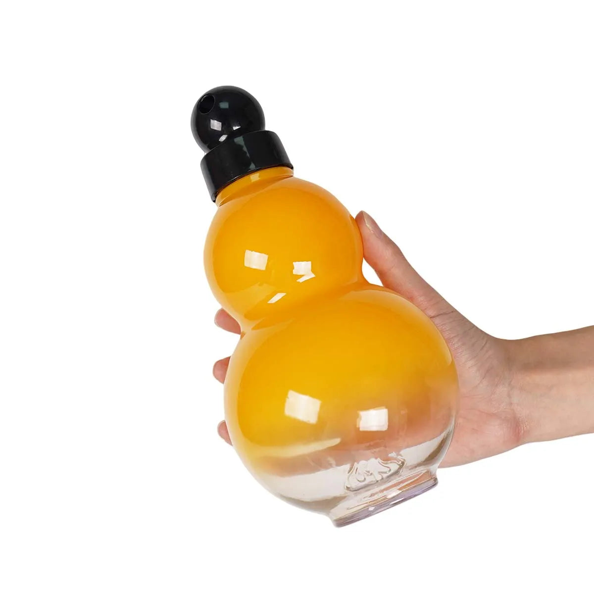 Eine Hand hält eine klare, krugförmige Sportflasche mit orangefarbiger Flüssigkeit und schwarzem Deckel.