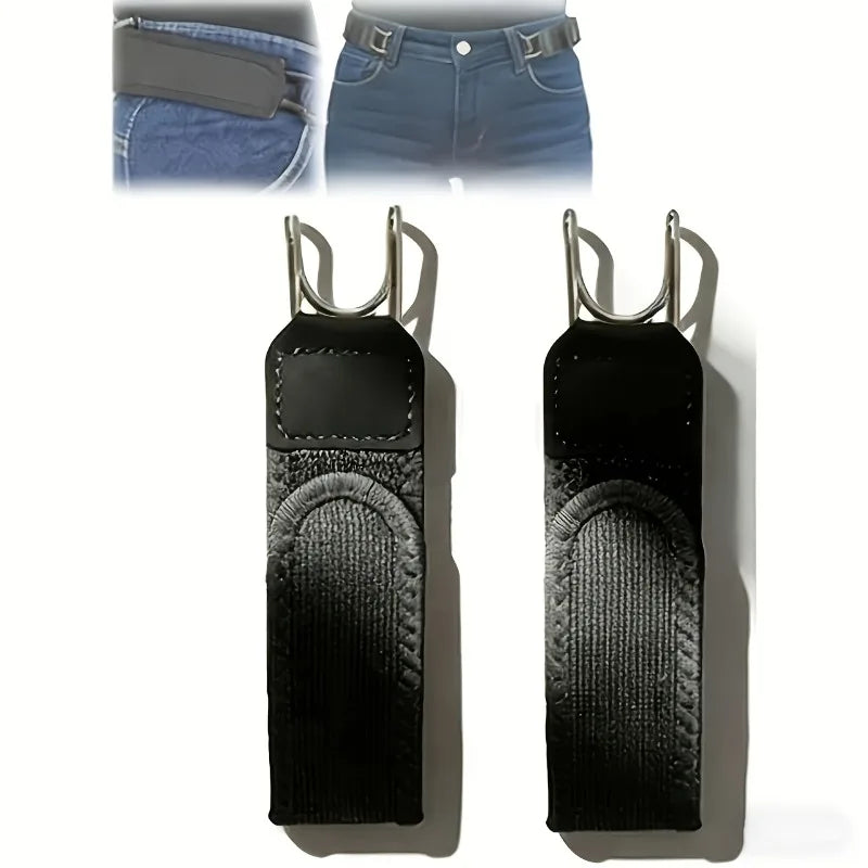 Ceinture élastique noire avec boucles argentées, à côté d'une ceinture de jean.