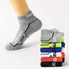 A stack of gray athletic socks with black detailing and neon colored socks on a white background.