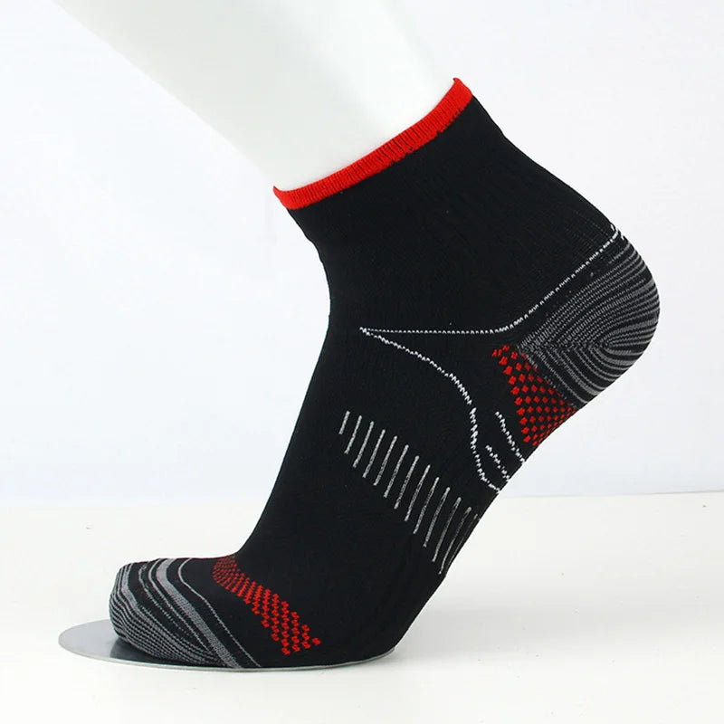 Bas de compression noirs avec bordure rouge et motifs géométriques sur la jambe d'un mannequin blanc.