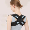 A woman wearing a black elastic support belt on her shoulder, demonstrating the fitness product.