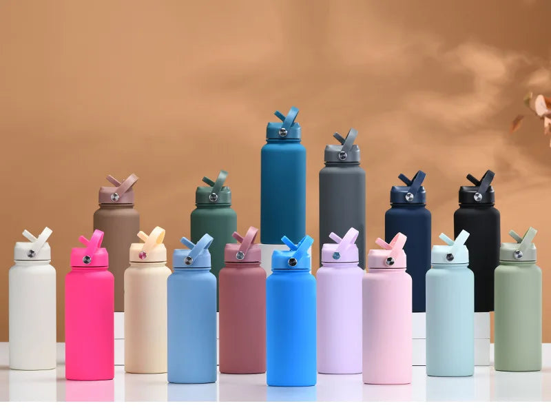 A collection of colorful stainless steel vacuum flask water bottles in various shades including pink, blue, green, and black.