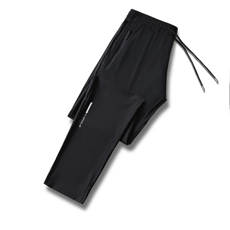 Black men's ice silk performance pants laid flat with drawstring visible