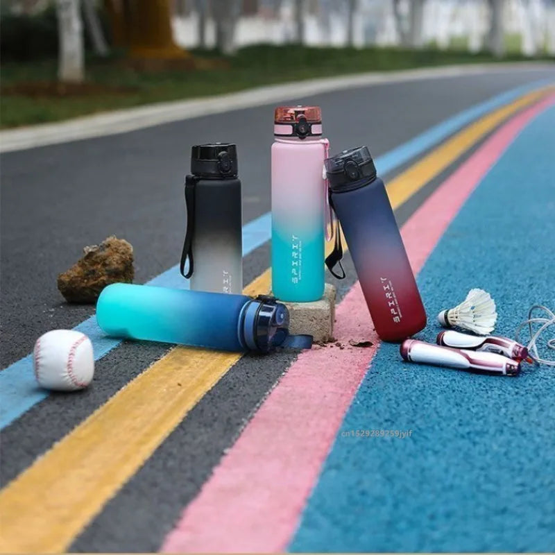 A collection of gradient insulated sports water bottles in various colors resting on a striped asphalt road.