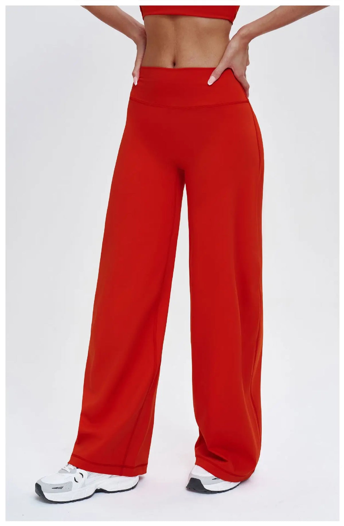 A model wears high-waist wide-leg yoga leggings in a vibrant red color.