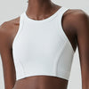 A model wears a white ribbed high-impact stretch yoga crop top.