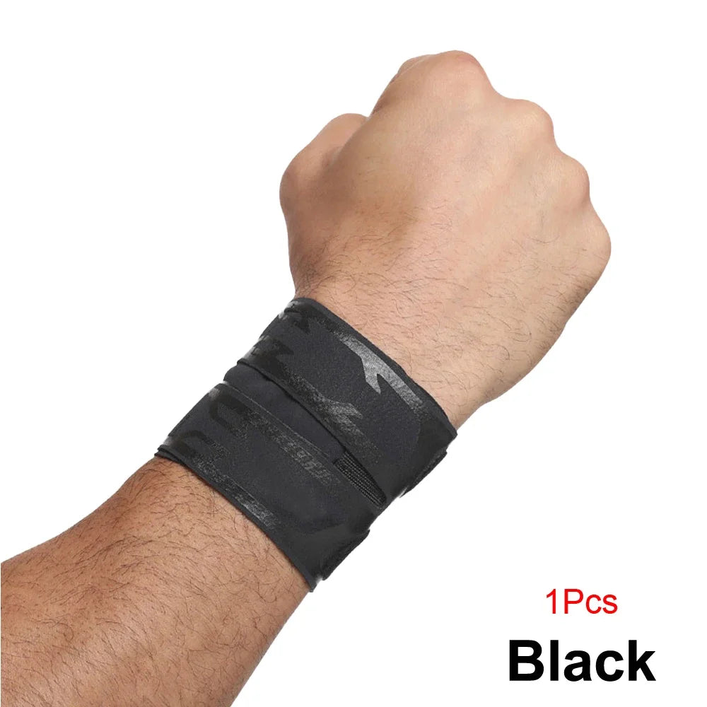 A hand wearing a black camouflage wrist support brace on the forearm.