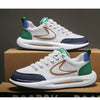 A pair of white and green men's breathable mesh running shoes are displayed on a cardboard box.