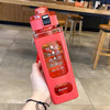 A hand holds a bright pink leakproof sport water bottle with various time markers on the side.