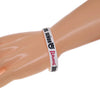 A close-up of a light skin tone arm wearing a white silicone wristband bracelet with black text.