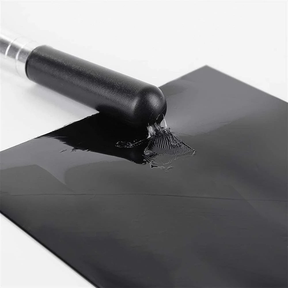 Ein schwarzes Applikatorwerkzeug trägt wasserdichte Reparaturband auf eine dunkle Oberfläche.