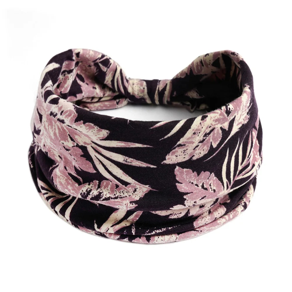 A dark floral patterned bohemian cotton stretch headband worn around the neck.