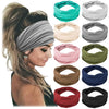 Una colección de diademas de tela en gris, rosa, verde oliva, beige y azul marino en el cabello de una mujer.