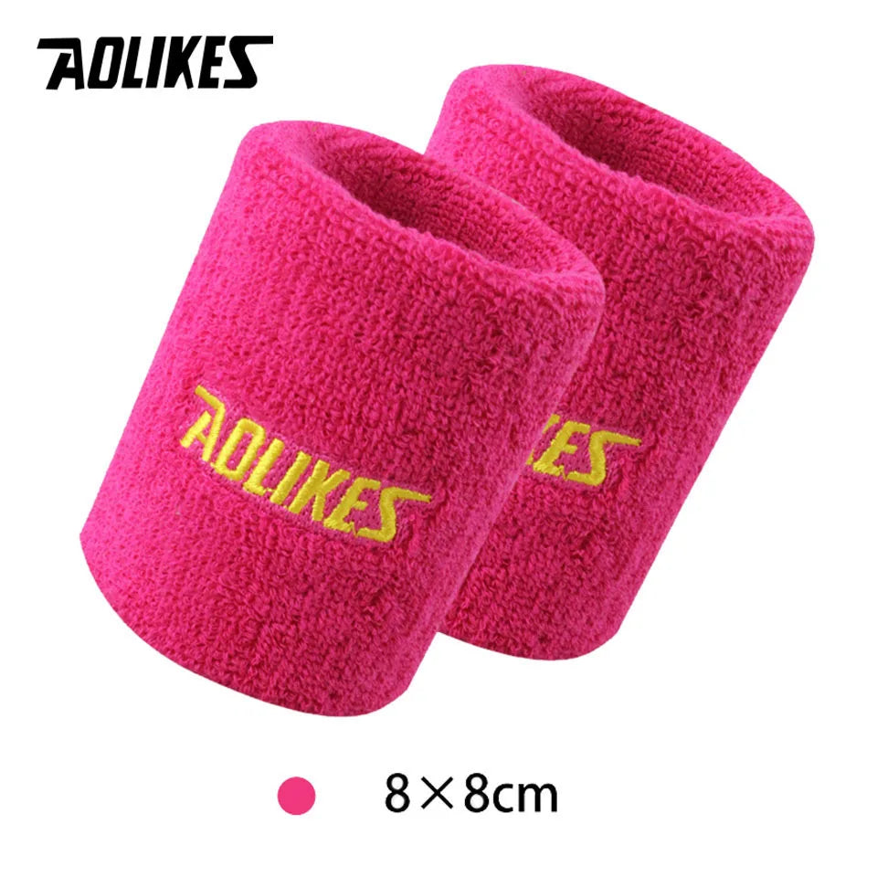 A pair of bright pink, fuzzy sport wristbands for activewear.