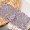 Primer plano de una diadema de encaje floral gris sobre una cesta tejida.